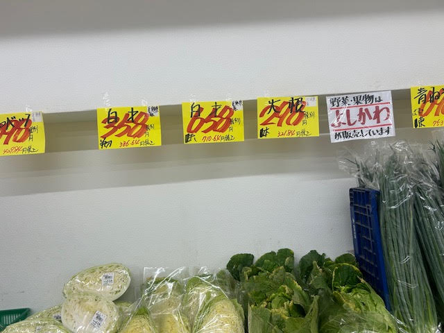 スーパーの野菜売り場の価格表示と陳列された野菜